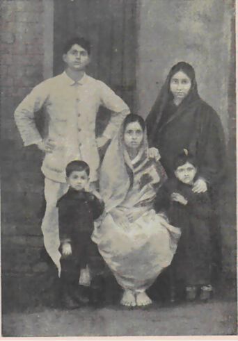Group photograph dated 1912 of six people, adults and young children, standing and seated before a doorway.